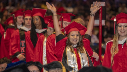 graduate raising arms in celebration