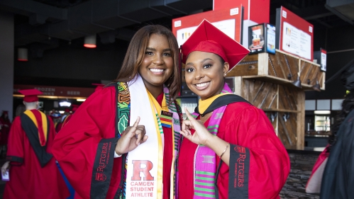 Graduates giving sorority hand sign