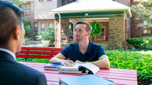 History students at table with open book and highlighter in hand