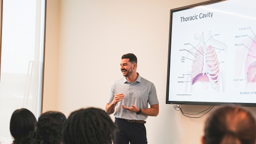 Professor stands in front of room by screen showing Thoracic Cavity.