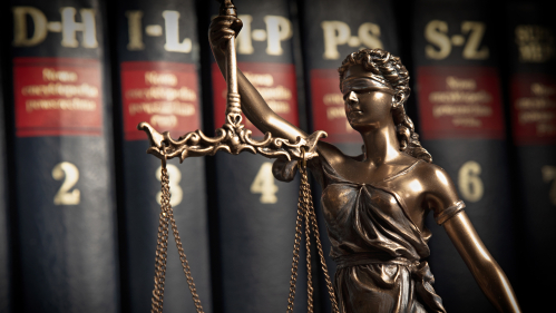 Lady Justice statue with law books in background