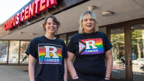 Students outside Campus Center wearing Rutgers Camden Philadelphia Pride Flag and Progressive Pride Flag shirts.