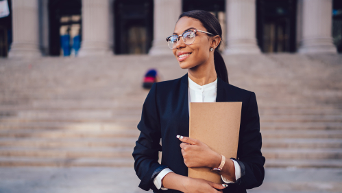 Woman holding folder in front of courthouse steps