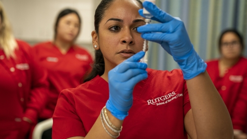 woman filling syringe with vial