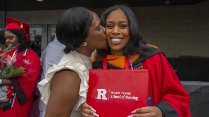 Commencement 2024 mom kissing graduate