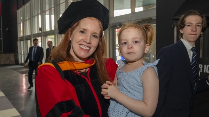 Commencement 2024 graduate holding child