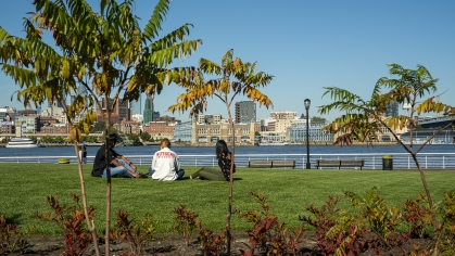 students sitting on grass looking at Philadelphia Skyline