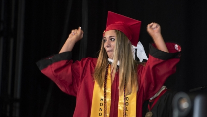 student raising hands in jubilation