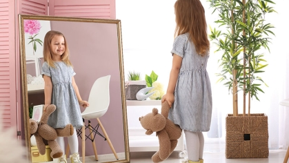 child standing in front of mirror