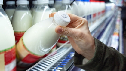 Person looking at expiration date on milk bottle