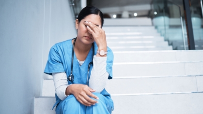 Nurse holding her head in weariness