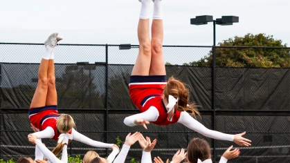 Cheerleader doing back flip in air