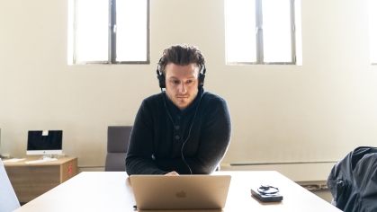 man with headphones on at laptop