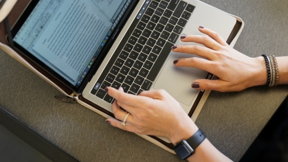 hands typing at laptop