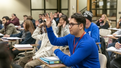 student raising hand during lecture