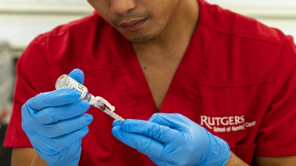 a male Rutgers nursing student filling a syringe