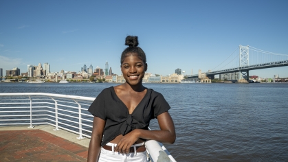 woman standing at harbor with philadelphia skyline in background