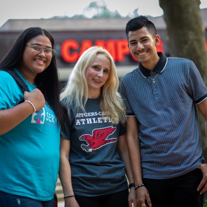 Three Smiling Students in front of the Campus Center