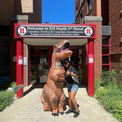 Student hugging mascot in front of Residence Hall