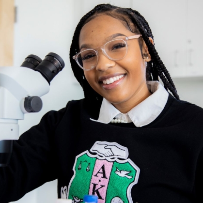STEM student in front of microscope
