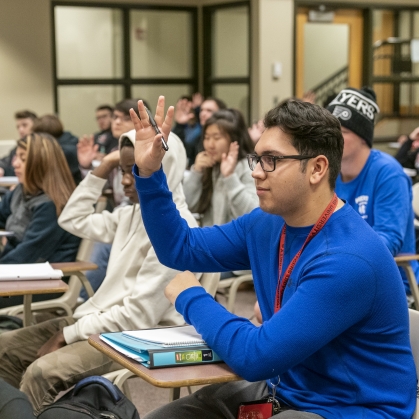 student raising hand during lecture