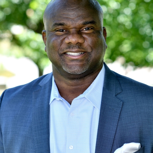 Dallas A. Grundy dressed in blue blazer smiling