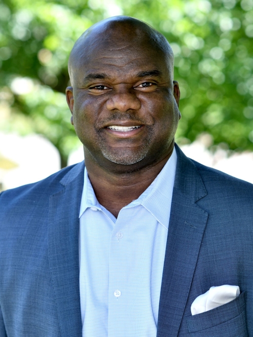 Dallas A. Grundy dressed in blue blazer smiling