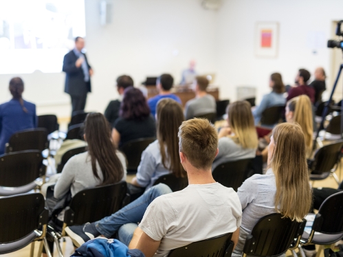 students in lecture hall with professor teaching class