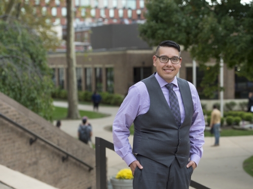 Andrew Abeyta standing outside on a campus building's steps