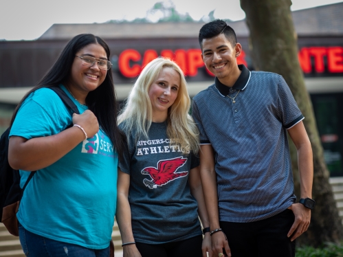 Three Smiling Students in front of the Campus Center