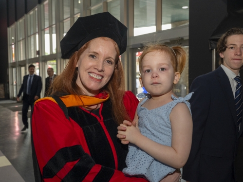 Commencement 2024 graduate holding child