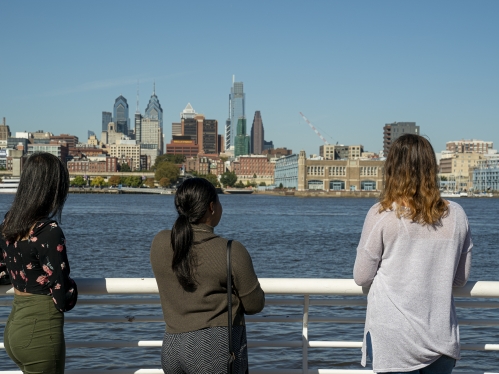 students looking over Delaware River onto Philadelphia skyline