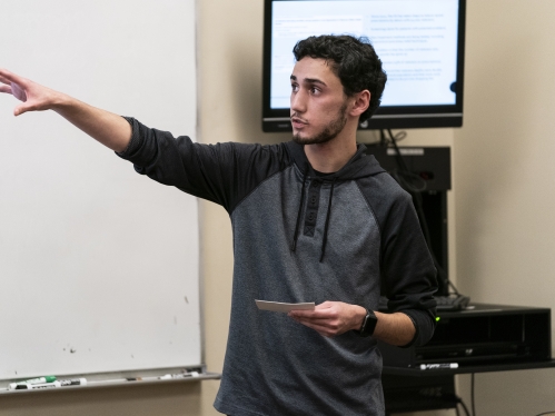 student giving demonstration at front of class