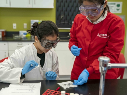 two women in safety gear working in lab