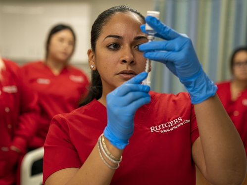 woman filling syringe with vial