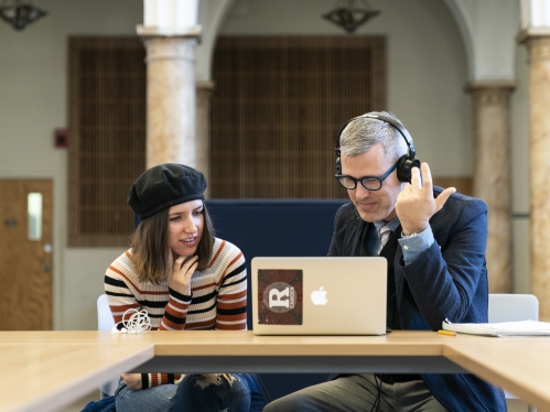 professor and student at laptop