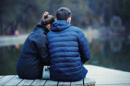 couple sitting at edge of water