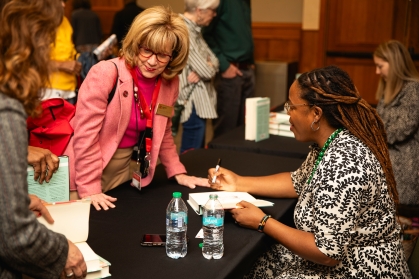 Author Heather McGhee signs copies of her book "The Sum of Us" during the 2025 Chancellor's Lecture Series