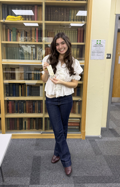 Student shows a bookmark from the workshop she taught to undergraduates