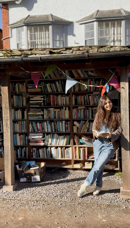 Student stands in front of a book stand in Wales during her Fulbright experience