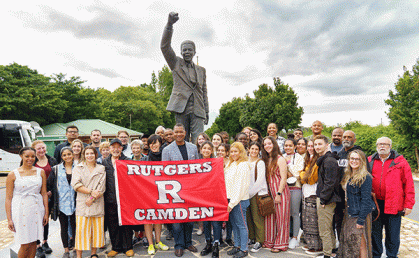 Rutgers Learning Abroad Program highlighting students in South Africa trip. Pictured are a group of Rutgers-Camden students in from of a statue of Nelson Mandella.