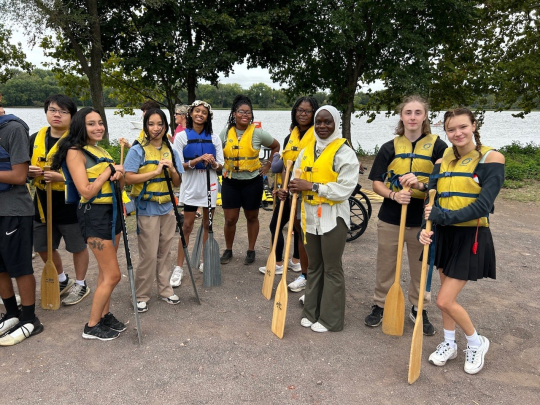 Honors College Impact Day Boat Trip: Group of students holding paddles on shoreline