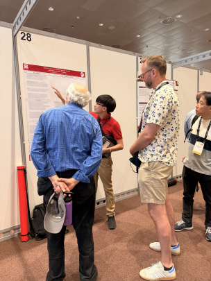 Professor observes student presenting at a poster session