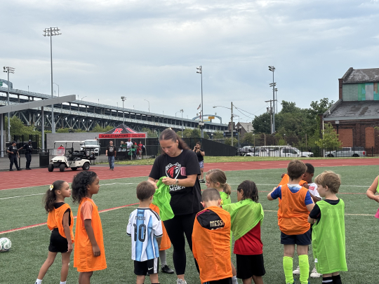Rutgers-Camden soccer players with kids at SoccerFest26.