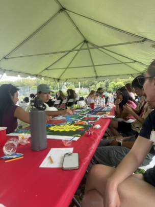 Honors College Impact Day Boat Trip: Group of students eating together under tent